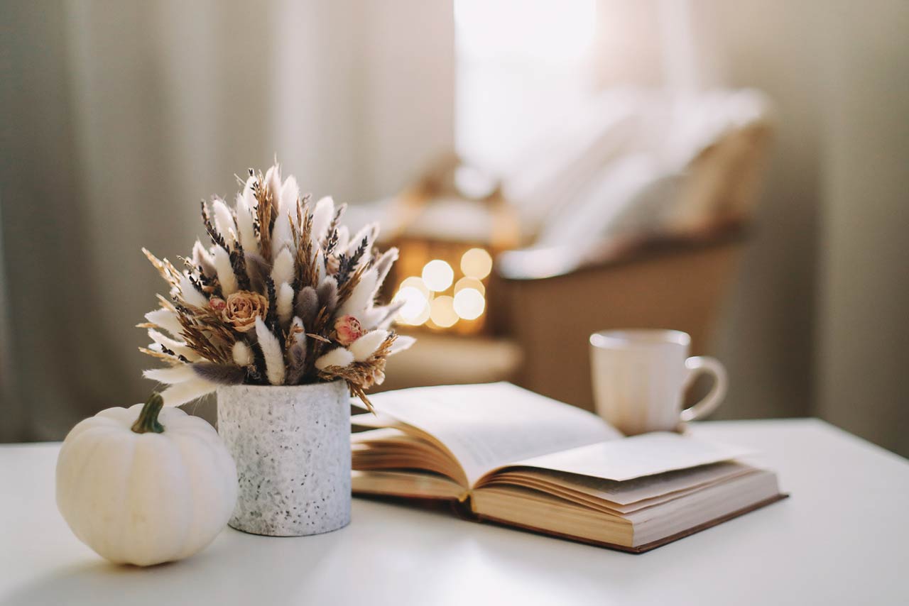 Fall home decoration stock photo with dried flowers, book, and a teacup