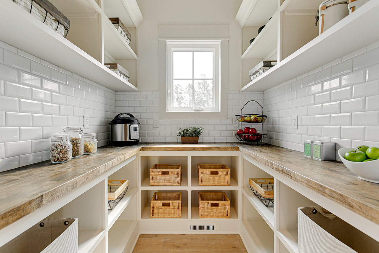 An organized pantry featuring wooden shelves and storage baskets, providing ample space for kitchen essentials